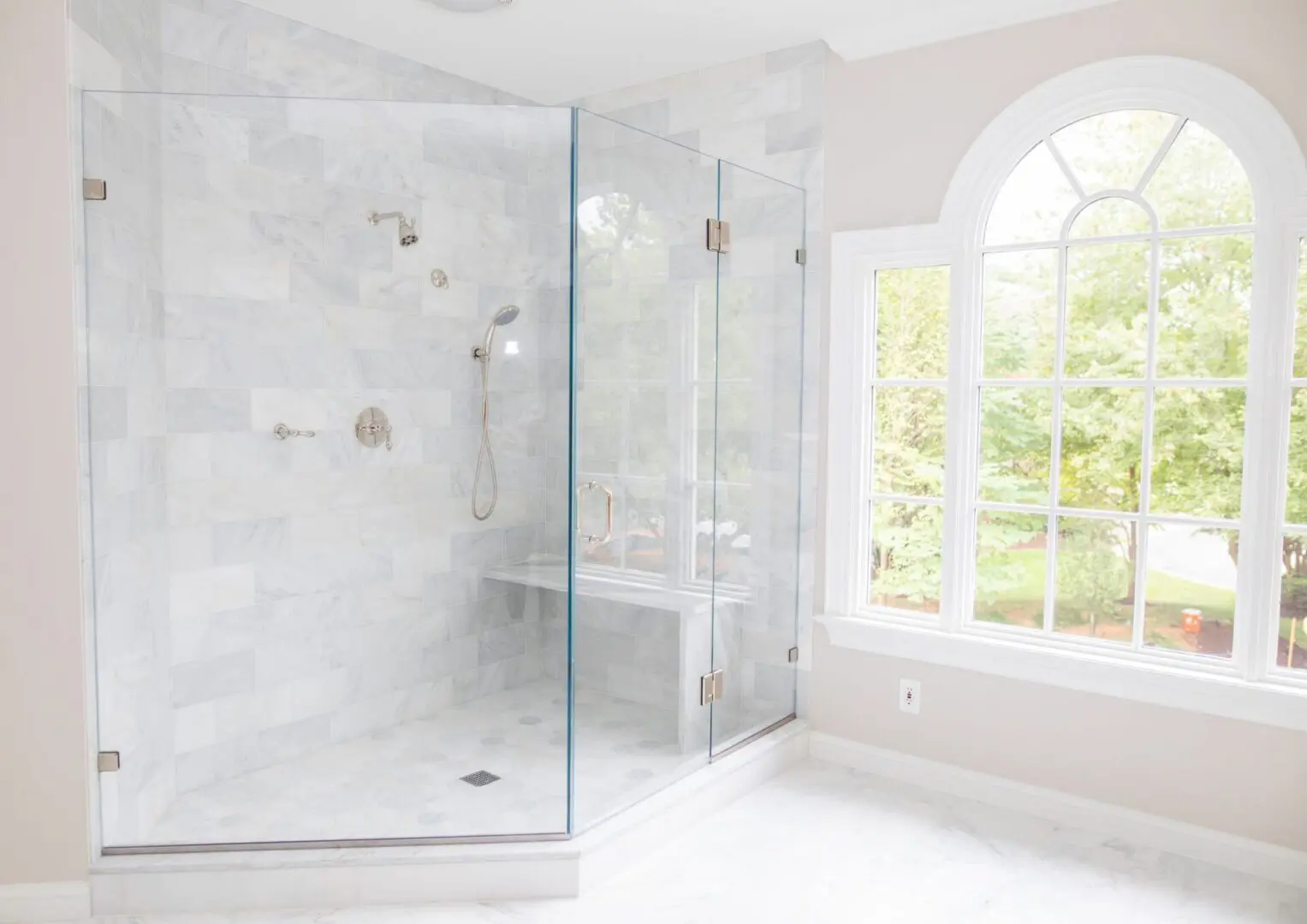 A large bathroom with a walk in shower and window.