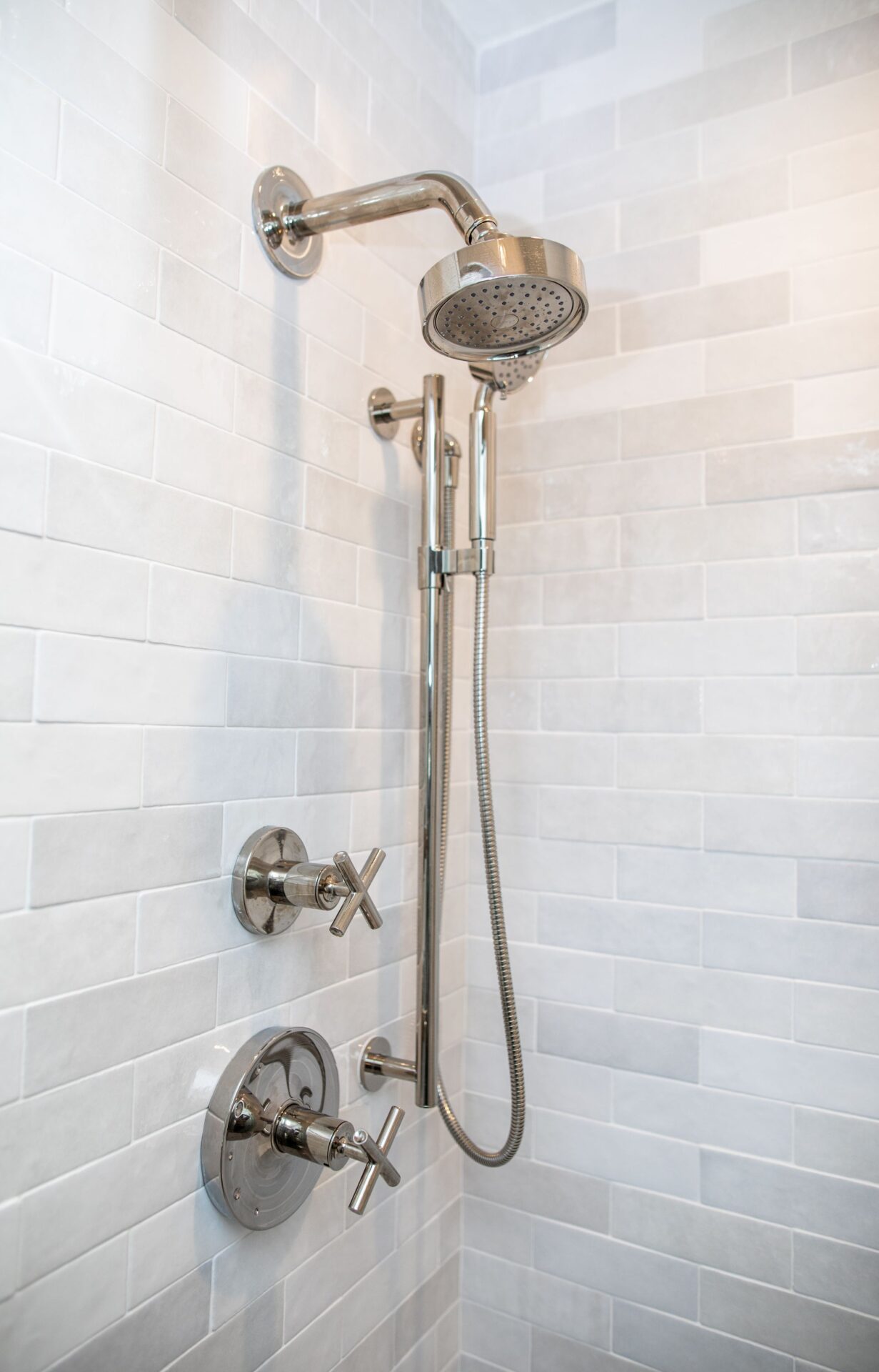 A shower with a silver head and hand held shower.