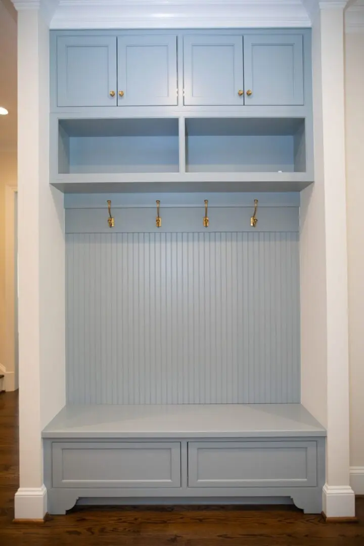 A blue cabinet with hooks and drawers in it